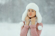 © rohappy - Young woman outdoors, girl in winter hat, sweater on snowy forest background with snowflakes