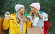 © rohappy - Happy smiling women friends with shopping bag, holding plastic credit bank card in winter, Christmas