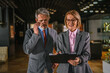 © Miljan Živković - Senior business colleagues discussing document on clipboard walking in office
