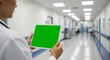 © A. Intelligence - Medical professional holding digital tablet with green screen in hospital hallway