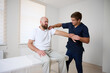 © Василь Івасюк - Chiropractor adjusting male patient’s shoulder in clinic. Physiotherapist performing manual therapy to relieve pain, improve mobility, support rehabilitation after injury or musculoskeletal disorder.