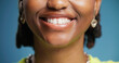 © peopleimages.com - Smile, dentistry and teeth of woman in studio with oral hygiene, veneers or tooth whitening. Happy, orthodontics and mouth of person with dental care for wellness with fresh breath by blue background