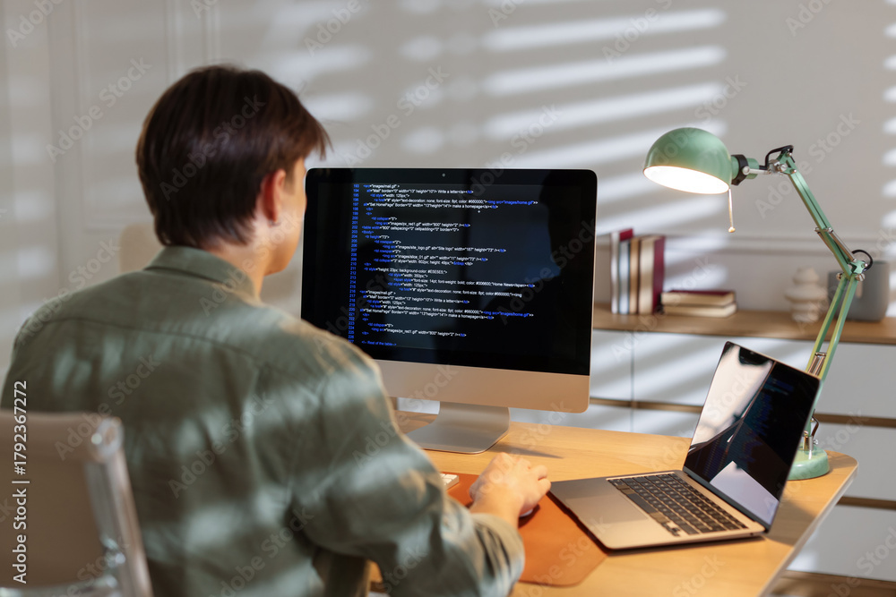 Programmer working on computer at table in office, back view Stock ...