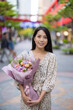 © leungchopan - Young woman enjoying fresh flowers outside