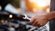 © fotofabrika - Mechanic works on car engine during sunset at a garage