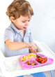 © yanadjan - The child eats pasta and vegetables. Selective focus.