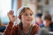 © sashka1313 - Teen Girl with Hearing Aid Raising Hand in Classroom