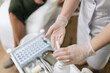 © dikushin - Close-up top view of medical professional in protective gloves sanitizing hands with pump antiseptic on portable cart before procedure like blood sampling, with essential supplies nearby.