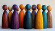 © dhita - Colorful wooden figures stand closely together, showcasing diverse shapes and hues that emphasize unity and creativity in design.