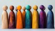 © dhita - Colorful wooden figures arranged in a row, showcasing various hues and textures, symbolizing diversity and creativity.