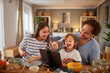 © Stockphotodirectors - A family spends quality time around the table, sharing laughter and food. The joyful atmosphere highlights their connection and togetherness during mealtime.
