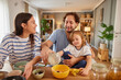 © Stockphotodirectors - A family shares laughter and joy as they prepare snacks in their welcoming kitchen. The warm sunlight fills the room, highlighting their happy moments together.
