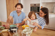 © Stockphotodirectors - A cheerful family enjoys breakfast at their kitchen table, with a child tasting food and parents smiling. This scene captures a warm moment of family togetherness.