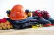 © Sergey - Safety helmet, safety shoes, safety suit, earmuffs, goggles cutresistant gloves on wooden table. Work safety protection equipment.