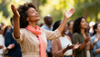 © Anna - Mature Black woman with hands raised in worship during an outdoor service. Spiritual person expressing faith and praise in a diverse community