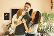© Louis-Paul Photo - Portrait of beautiful couple stand, smile and hug at home with basset dog