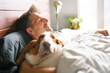 © Louis-Paul Photo - man and her Basset dog at home bed