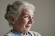 © AnnaStills - Senior Caucasian woman smiling gently while looking away, showing wrinkles and gray hair, closeup capturing thoughtful expression and signs of aging on face