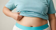 © ismail - Person's hand pinching their belly fat, reflecting body image concerns, weight management challenges, and the pursuit of a healthier physique and lifestyle goals