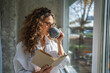 © Miljan Živković - Woman enjoying morning coffee and reading book at home
