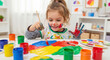 © aziz - Young girl joyfully paints with colorful finger paints creating art