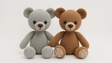 Two knitted teddy bears, one grey and one brown, sitting side by side with round paws and large ears, on a plain light background.