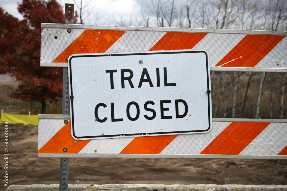 sign and barrier indicates that a trail is closed due to construction ...