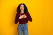 © deagreez - Young mixed race woman smiles with hands on chest against bright yellow background in casual fashion lifestyle portrait