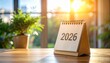 © faiz_99 - Close-up of 2026 desk calendar on wooden table with soft light and clean workspace. Perfect concept for planning, schedule, or time management design.