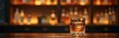 © miss irine - Elegant glass of whiskey sits on bar top with dark wood surface. Ice cube cools brown liquor in tumbler against blurred bottle shelf backdrop at night. Enjoy premium alcohol drink.