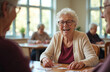 © miss irine - Happy senior women play cards together in a community center room. Friends enjoy a fun game of chance and social interaction during their day.