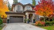 © VolumeThings - Luxury two story stucco home with garage and large tree surrounded by vibrant autumn scenery in Vancouver Canada November 2024