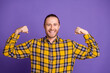 © deagreez - Young handsome guy in yellow plaid shirt flexing arms against purple background for lifestyle fashion promotional image