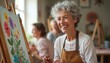 © miss irine - Senior woman smiles painting in art class with friends. Retired artist enjoys creative hobby alongside adults. Group learns new skills together in bright studio setting. Image represents lifelong