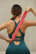 © zhagunov_a - Woman Stretching Back Muscles with Resistance Band Indoors