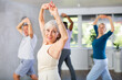 © JackF - Active senior lady enjoying passionate flamenco dance during group class with adult men and women. Concept of hobbies of older generation