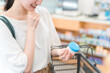 © buritora - A woman shopping for ointment at a pharmacy, drugstore, or convenience store