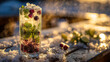 © Nad - A tall glass filled with a sparkling beverage features mint leaves, berries, and citrus slices. Sunshine creates a warm glow on the table covered in ice and snow.