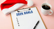 © NikProArt - A clipboard with '2026 GOALS' written on it, next to a Santa hat and a cup of coffee.