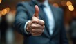 © Maryna - Man in suit gives thumbs up gesture. Professional indicates agreement and approval. Confident businessman shows positive feedback. Business success achieved. Good job acknowledged.
