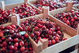 Fresh red sweet cherries in wooden crates prepared for sale on a market.
