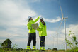 © Surachai - Wind energy technicians inspecting turbines green field outdoor scene renewable energy upward angle engineering insights