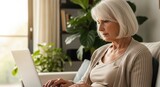 Senior's Digital Journey: An elegant senior woman with gentle determination, immersed in the digital world, skillfully navigating a laptop with the soft glow of a homey environment.
