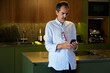 © JavierBallesterLegua - Man texting on smartphone in modern kitchen