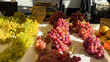 © CreativeArt - Fresh green and red grapes displaying at outdoor farmers market counter