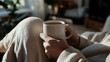 © photo for everything - Cozy scene: a person relaxing in soft attire holds a warm cup. Light streams in, creating a peaceful ambiance. A moment of simple pleasure, embracing warmth and comfort.