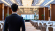 © Tee nuT - Hotel manager stands confidently in luxurious banquet hall, overseeing elegant setup for event, showcasing professionalism and attention to detail