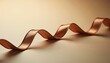 © Denis - Close-up of bronze ribbon on matte beige surface with warm soft lighting, simple elegant festive mood