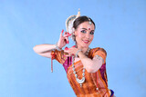 Indian dancer in the studio on a blue background in a dance pose