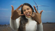 © Krakenimages.com - Woman hand rock windmill young latin hispanic field outdoor gesture creates dynamic photo.